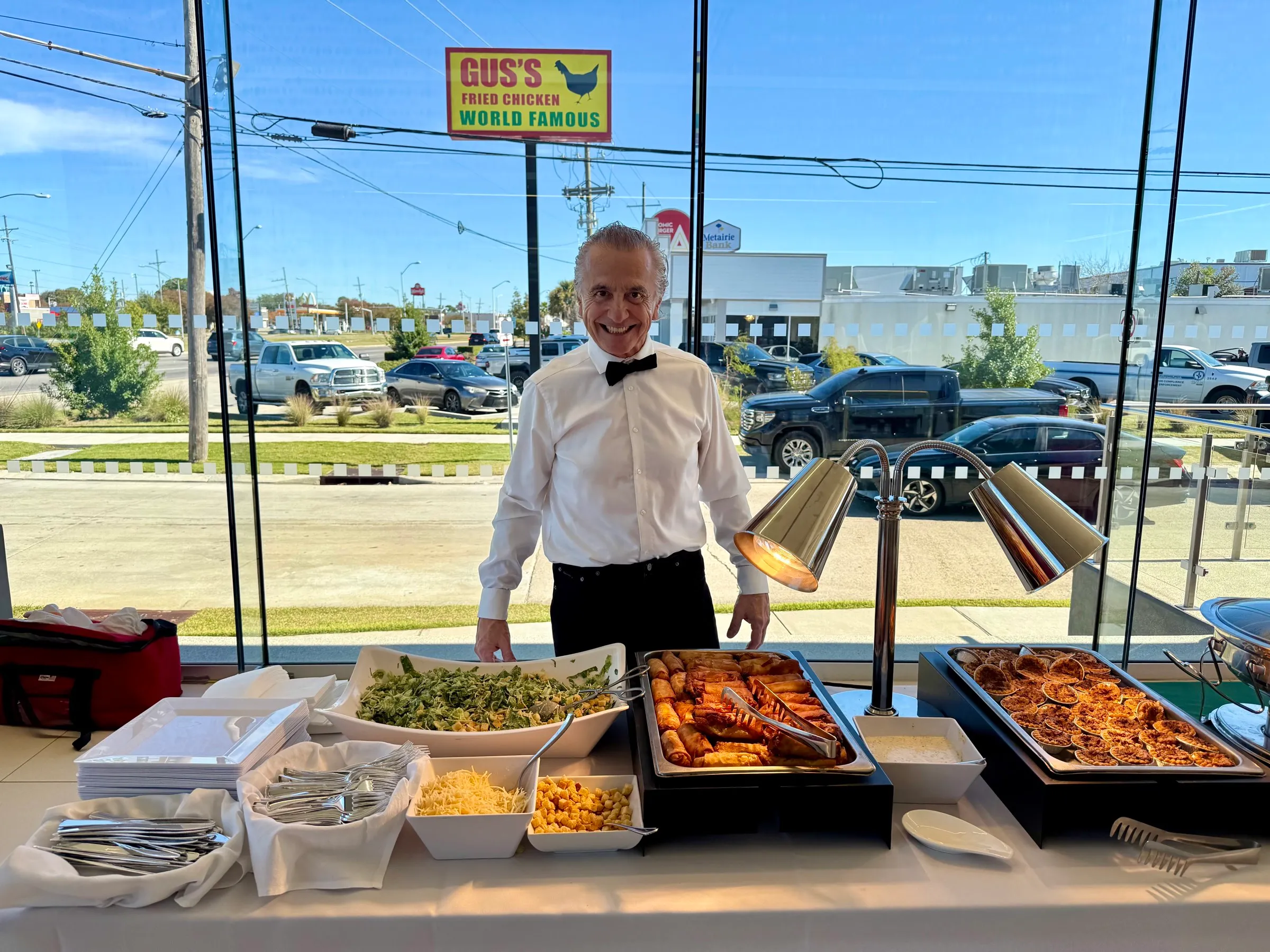 Uniformed server at a corporate buffet with chafing dishes and catered spread